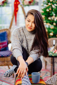 Full length of smiling woman sitting on table