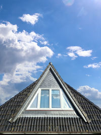 Roof window in velux style with black roof tiles