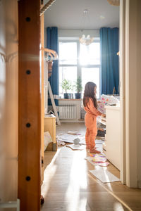 Side view of girl looking through window