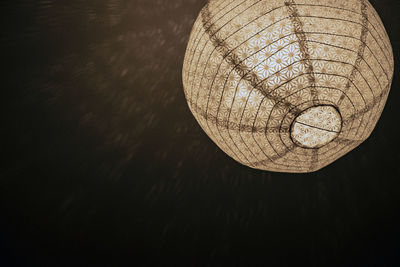 Low angle view of illuminated lamp hanging on ceiling