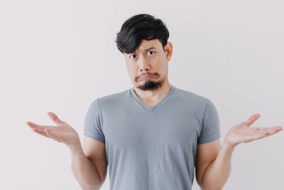 Portrait of young man standing against white background