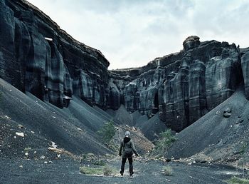 Full length of woman standing on mountain against sky