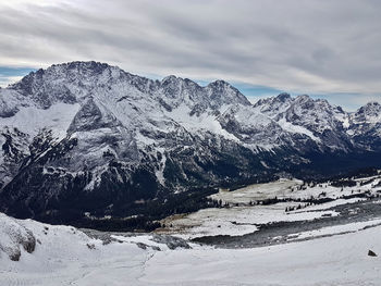 Scenic view of snowcapped mountains against cloudy sky