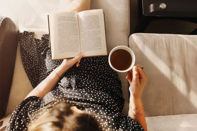 Midsection of woman holding coffee cup