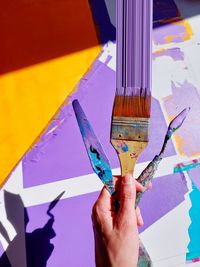 Cropped hand of woman painting on table