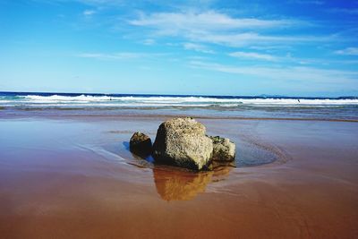 Scenic view of rocks on beach against sky