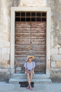 Full length portrait of woman sitting outdoors