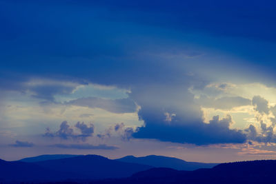 Low angle view of mountains against dramatic sky