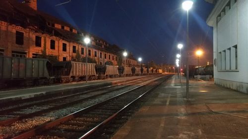 Railroad tracks in city at night