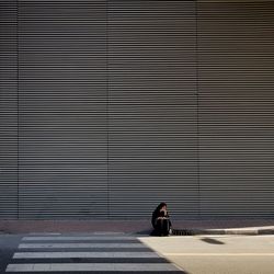 Full length of woman sitting on wall