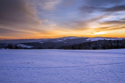 Scenic view of snowcapped mountains against sky during sunset