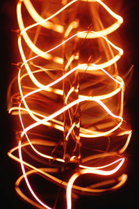 Close-up of illuminated lighting equipment against black background