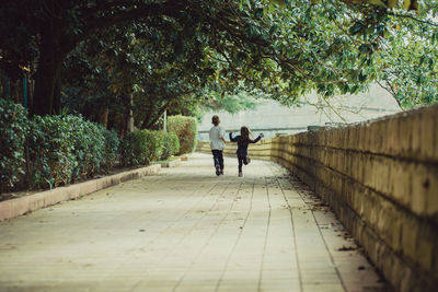 Two happy kids running away from the camera