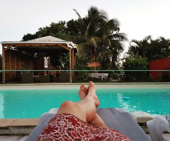 Low section of woman relaxing in swimming pool