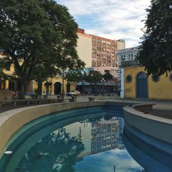 Swimming pool in city against sky