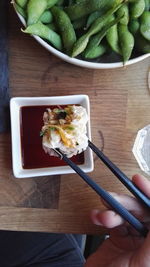 High angle view of hand holding food on table