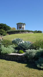 Built structure on field against clear blue sky