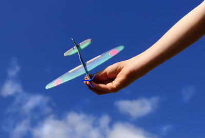 Cropped image of woman holding hands against clear sky