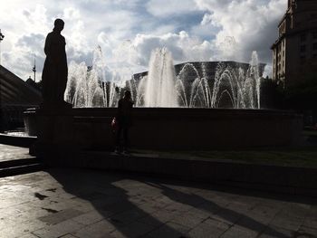 Silhouette of woman against cloudy sky