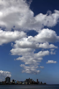 Buildings in city against cloudy sky