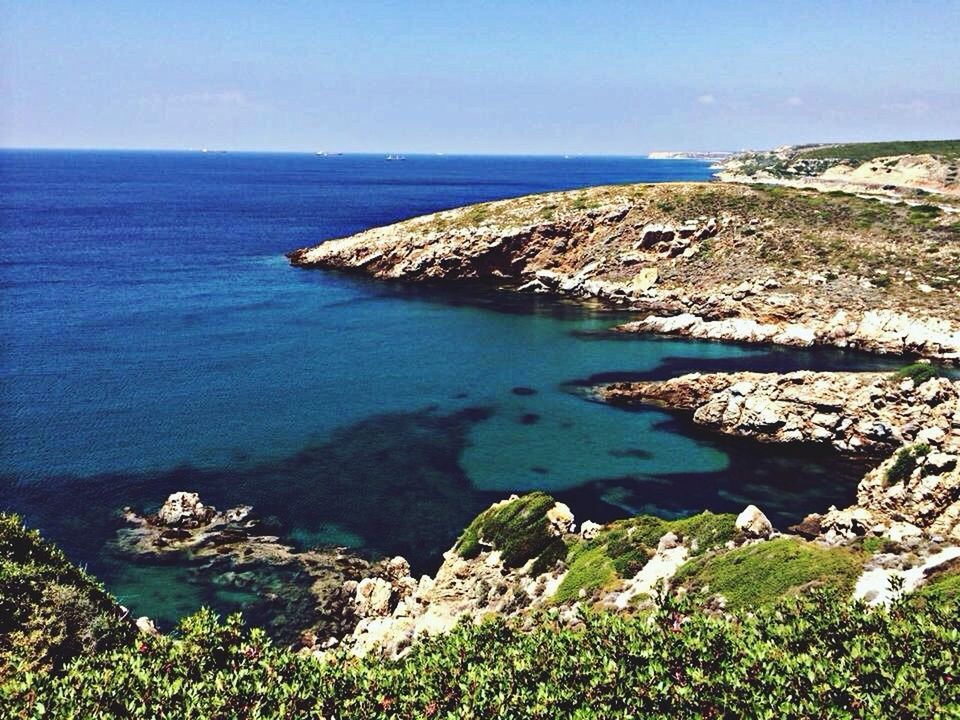 water, sea, tranquil scene, tranquility, horizon over water, scenics, blue, beauty in nature, nature, rock - object, cliff, high angle view, rock formation, idyllic, clear sky, rock, coastline, seascape, plant, day