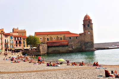 People at beach against clear sky