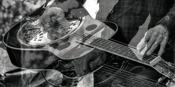 Double exposure of man playing guitar