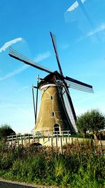 Traditional windmill on field against sky
