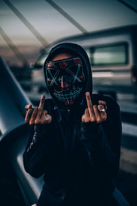 Portrait of man wearing mask gesturing outdoors