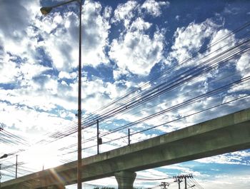 Low angle view of bridge against cloudy sky