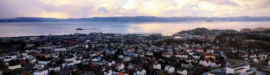 High angle view of city by sea against sky