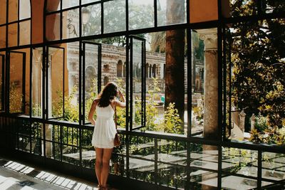 Full length of a young woman standing by railing