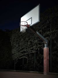 Low angle view of basketball hoop against sky at night