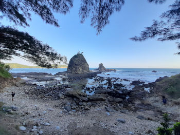 Rocks on beach against sky