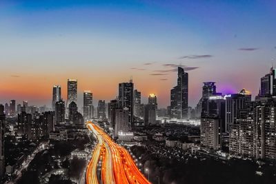 High angle view of cityscape against clear blue sky during sunset