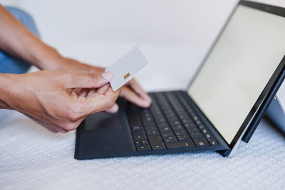 Unrecognizable woman doing online shopping with credit card and laptop. technology and business 