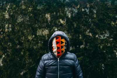Man covering face with fabric while standing outdoors