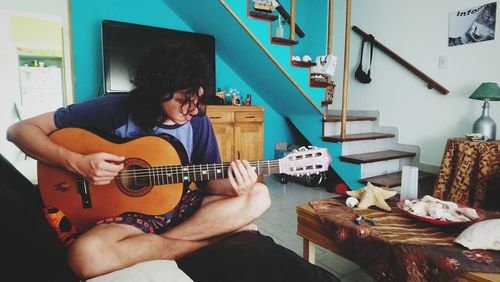 Man playing guitar at home