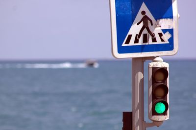 Close-up of road sign against blue sky