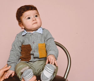 Portrait of cute boys sitting against white background