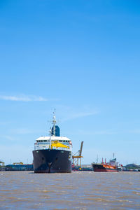 Ship moored at harbor against sky