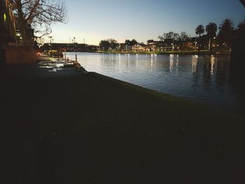 Scenic view of lake against clear sky at sunset