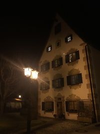 Low angle view of illuminated buildings against sky at night