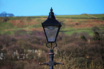 Close-up of old light bulb on field against sky