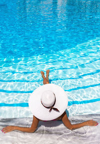 Woman sitting on swimming pool