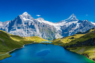 Scenic view of snowcapped mountains against clear blue sky