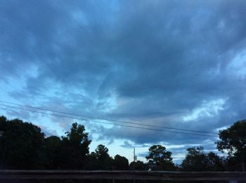 Silhouette of trees against cloudy sky