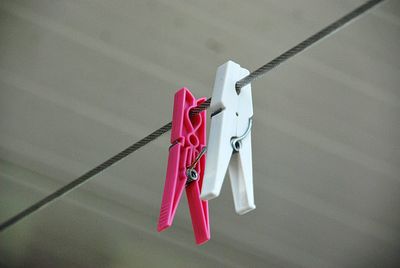 Close-up of flags hanging on clothesline against wall