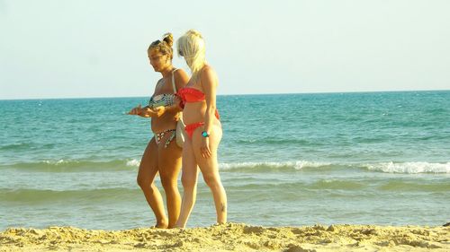 Full length of young woman standing at beach