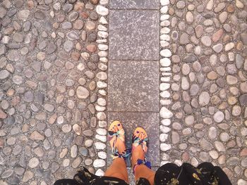 Low section of person standing on cabblestone street on medieval town